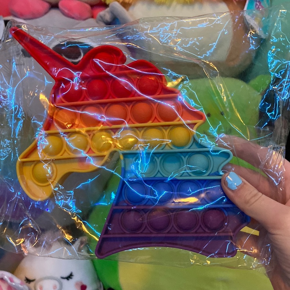 Rainbow unicorn fidget toy has unicorn heads on the pops